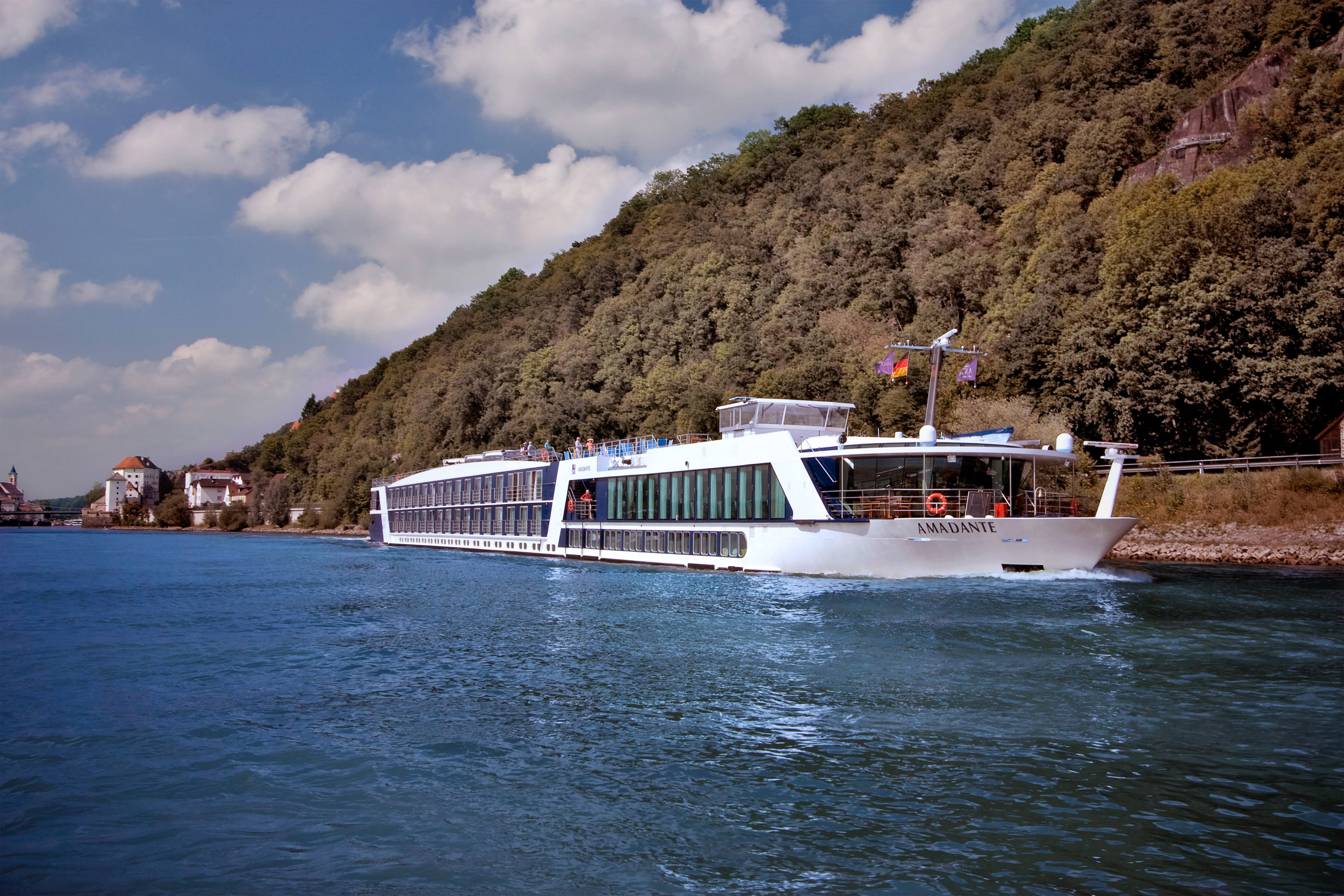 AmaDante cruising beside a wooded hillside